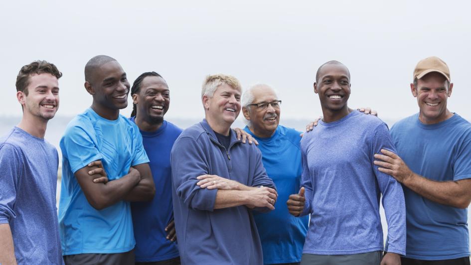seven men posing for photo in blue shirts