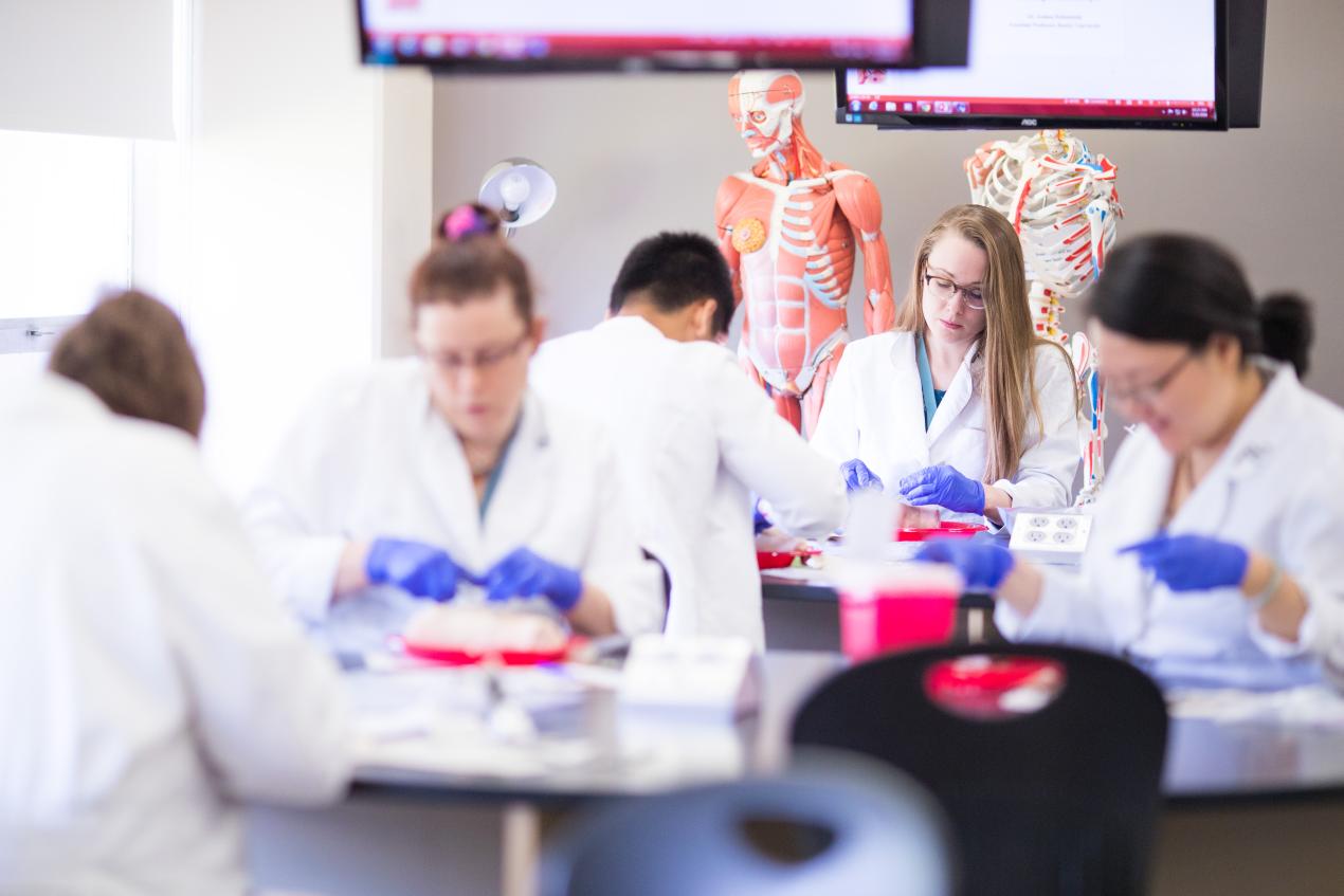 students in lab coats in a classroom