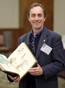 Alan Touwaide holding a book