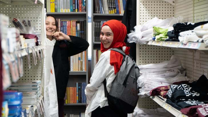 two students smiling in bookstore
