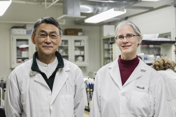 two faculty members wearing lab coats