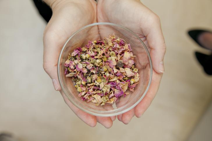 person holding bowl of herbs