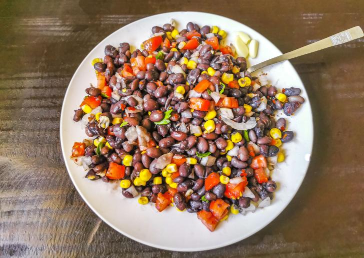 a salad with corn, kidney beans, red peppers, and onions 