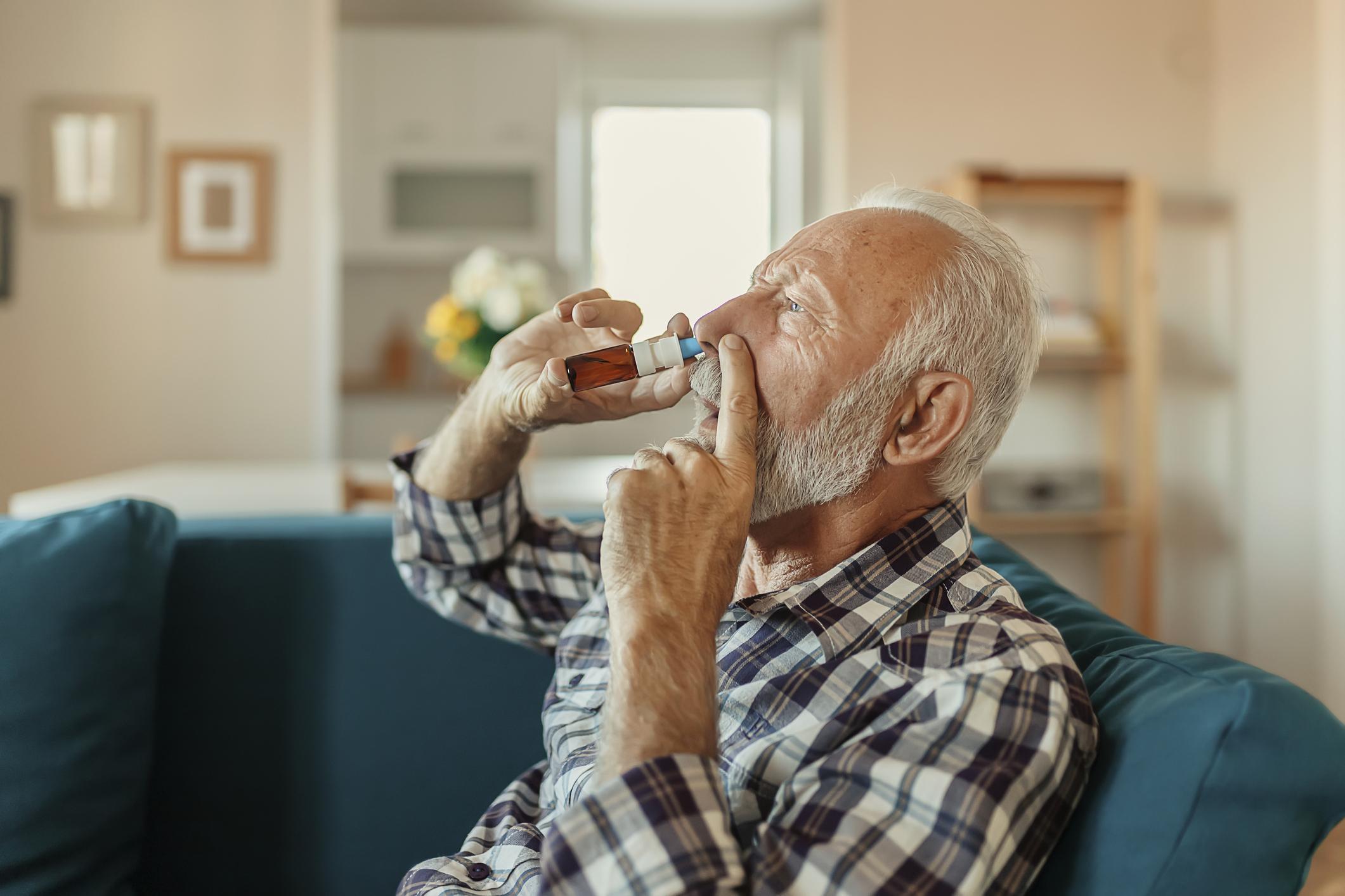 elderly man using nasal spray