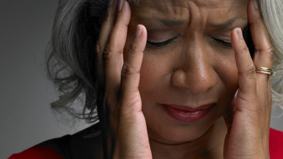 person holding hands to the temples of their forehead