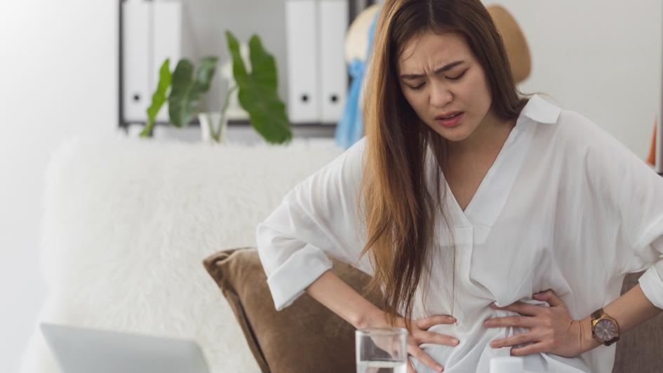 person hunched over grabbing the sides of their stomach