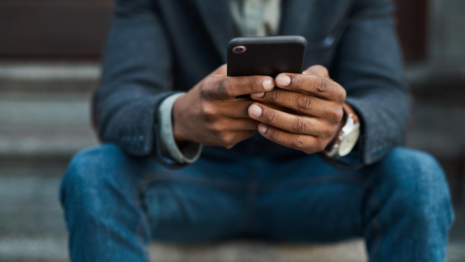 close up of person looking at cell phone sitting on steps