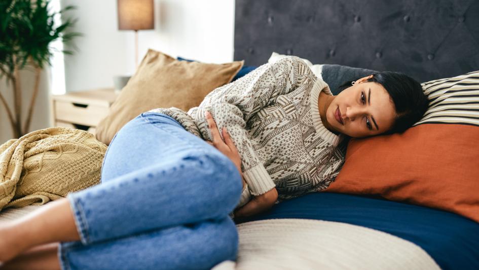 woman in pain laying on bed