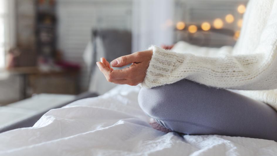 person meditating on bed