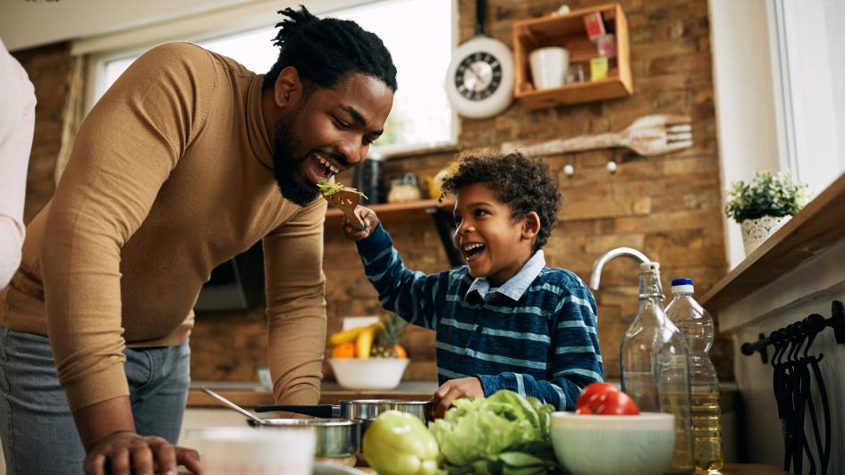 child feeding adult food in the kitchen