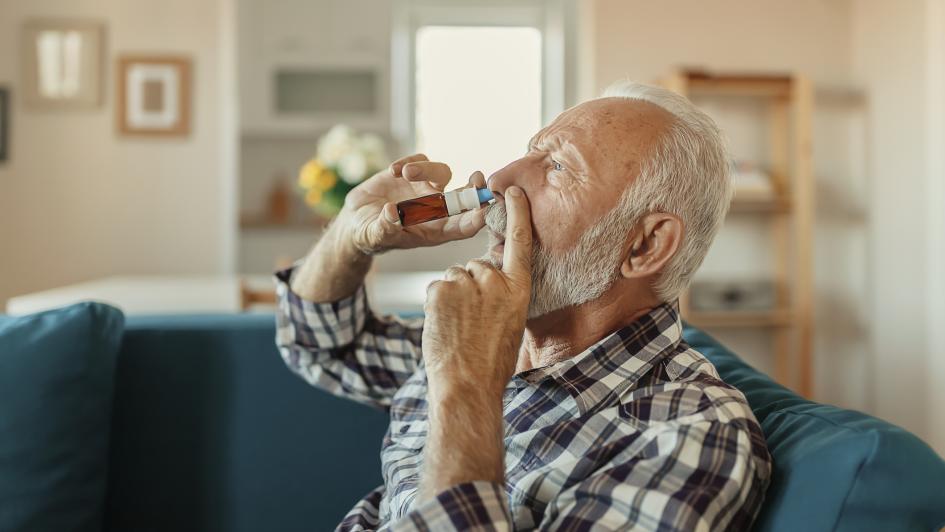 elderly man using nasal spray