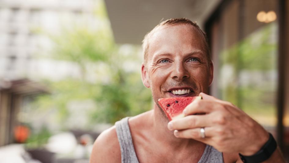 man eating a piece of watermelon