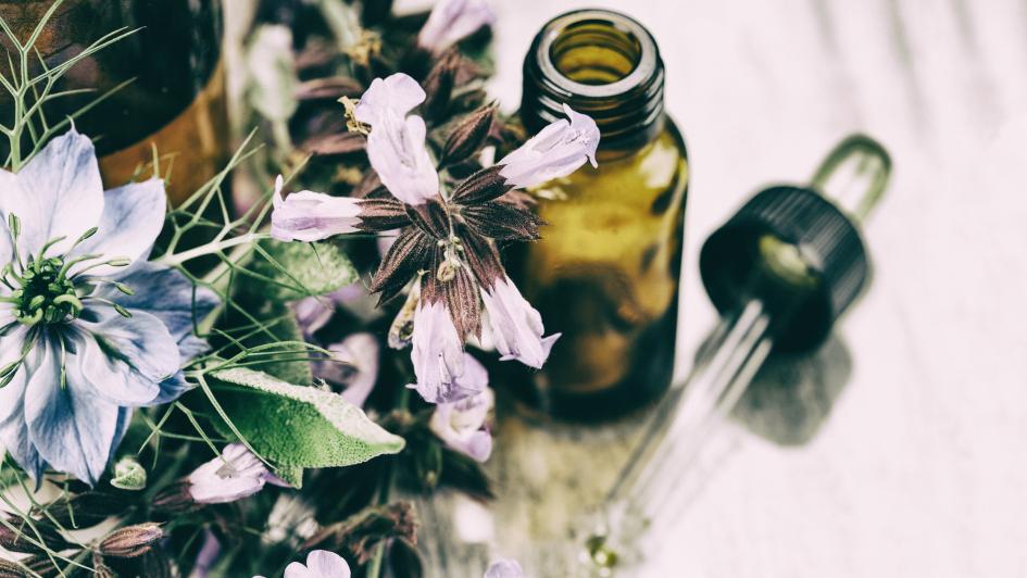 table with flowers, herbs and a dripper bottle