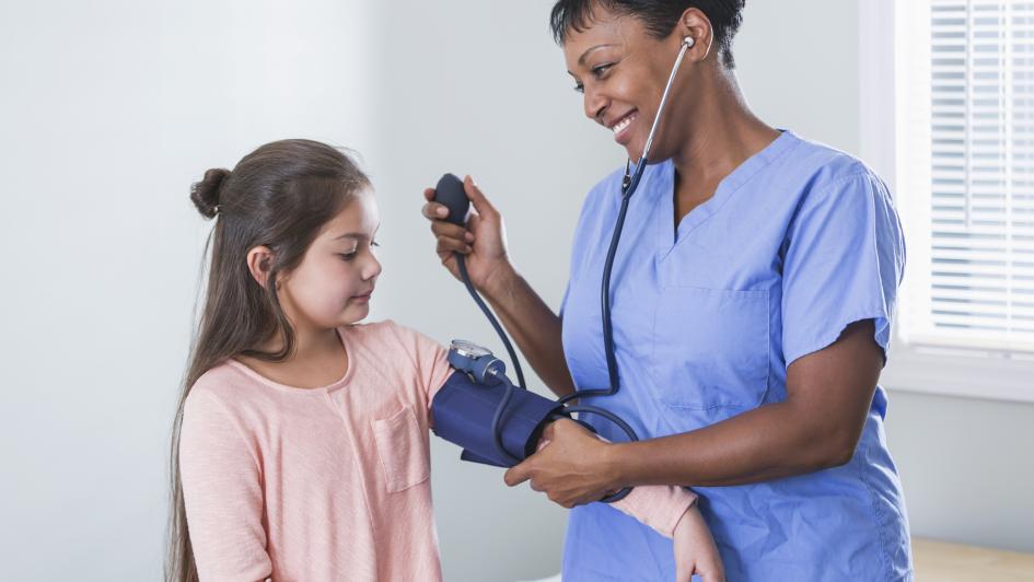 doctor checking a kids blood pressure