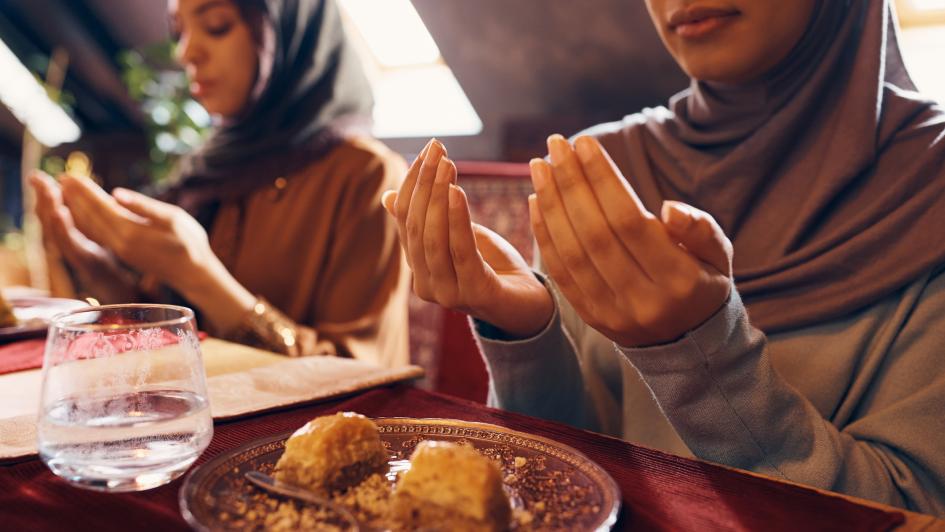 Close-up of Muslim woman starting the fast with dua at Suhoor during Ramadan