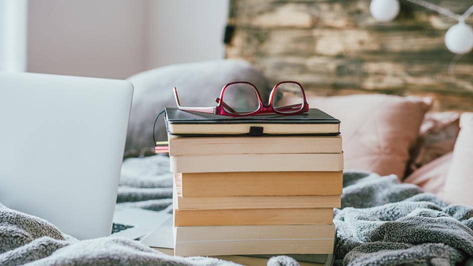 stack of books and glasses sitting on top