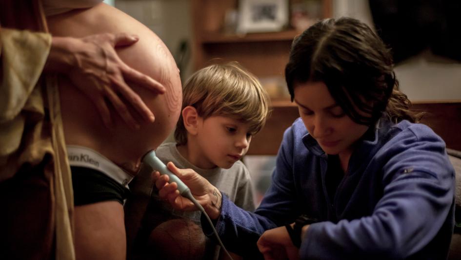 midwife checking a baby's heartbeat with a Dopler