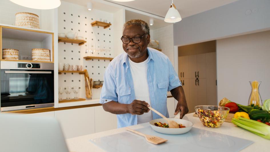 man cooking food looking at computer