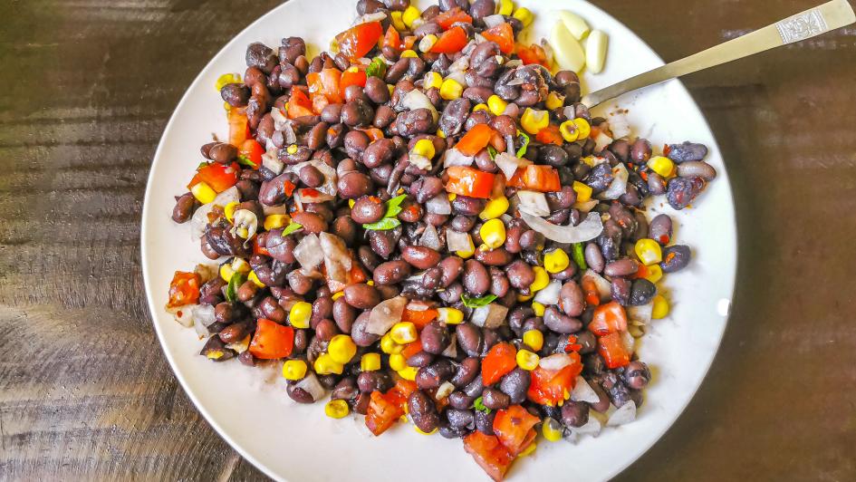 a salad with corn, kidney beans, red peppers, and onions 