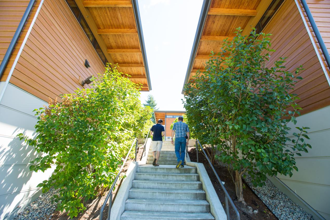 two students walking up steps to student village