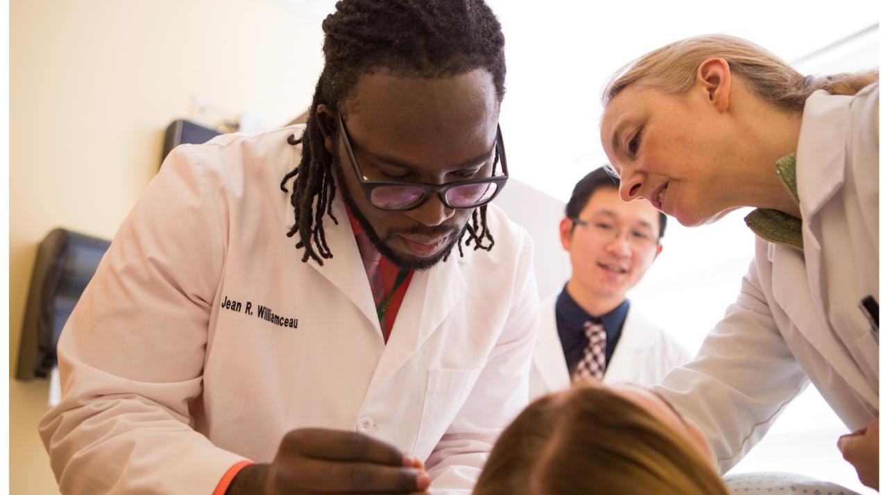 Three doctors examining a patient