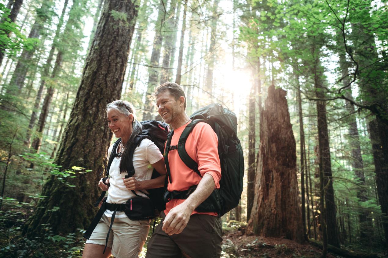 two older people hiking in forest